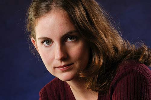 Professional studio portrait of a young woman with long brown hair wearing a red sweater, captured by Berkeley photographer EK Photo.